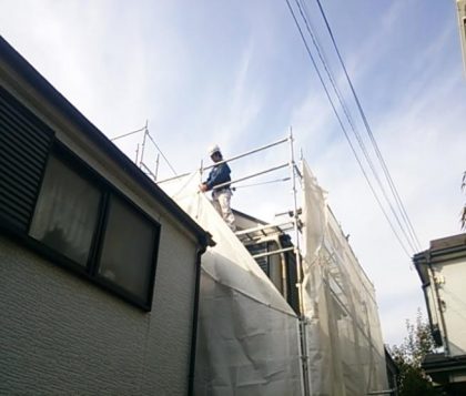 足場のメッシュシートを張る塗装専門店功栄の職人