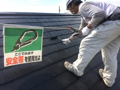 安全帯を付けサーモアイを上塗り塗装中の功栄の職人